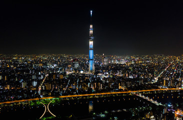 Obraz premium Aerial view of Tokyo Skytree, Sumida river, and Japanese landscape in Tokyo city at night. Japan tourism, cityscape landmark, Asia travel destination, or modern building architecture concept