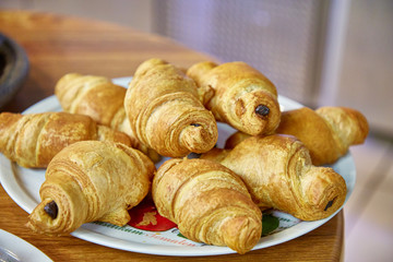 Chocolate croissants sprinkled with powdered sugar lie on a plate