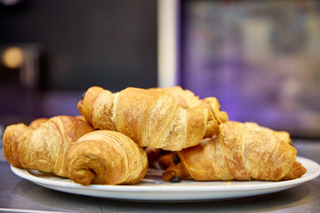 Chocolate croissants sprinkled with powdered sugar lie on a plate