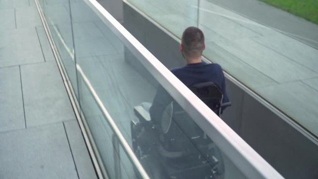 4k resolution follow back view of a man on electric wheelchair using a ramp. Accessibility concept