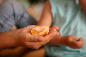 peeled slice of tangerine lies in the palm of a person's hand close-up