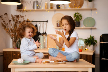 two little girls prepare Christmas cookies in the kitchen