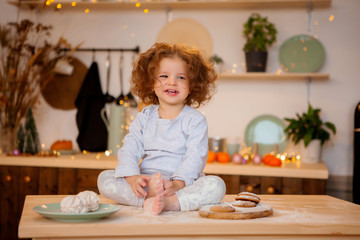 little girl sitting in Christmas kitchen on table
