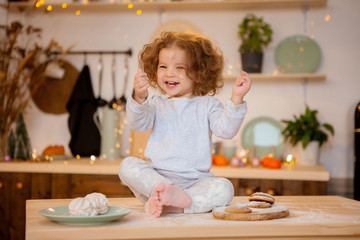 little girl sitting in Christmas kitchen on table