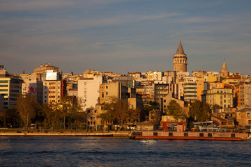 Fototapeta na wymiar Galata tower view from the boat at sunset. Trip in Bosphorus by ferry. Turkish landmarks concept. 