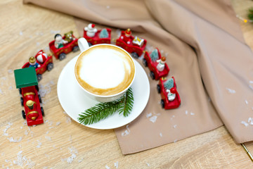 Delicious fresh festive morning cappuccino coffee in a ceramic white cup on the wooden table with...