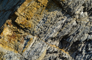 Striped natural texture of stones and rock fragments on Caucasus mountains on Black Sea coast in Olginka as original texture background. Brown, yellow, gray colored stone. Nature concept for design