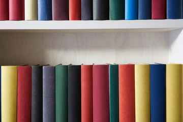 Close up of colorful book covers in a white shelf