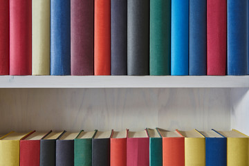 Close up of colorful books in a white shelf