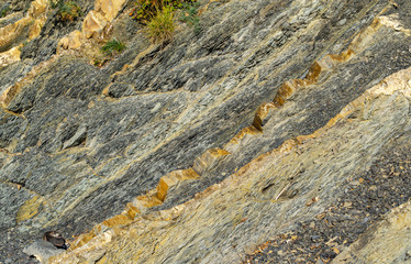 Striped natural texture of stones and rock fragments on Caucasus mountains on Black Sea coast in Olginka as original texture background. Brown, yellow, gray colored stone. Nature concept for design