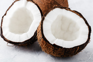 The ripe coconut is split in half, whole coconut, on light background, close up