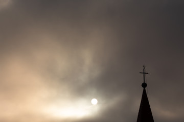 Sol encoberto pela neblina marítima e igreja