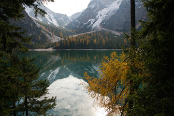 Fototapeta na wymiar Wandern im Herbst rund um den Pragser Wildsee mit schöner Bergkulisse in den Dolomiten in Südtirol Italien. Bunte Bäume