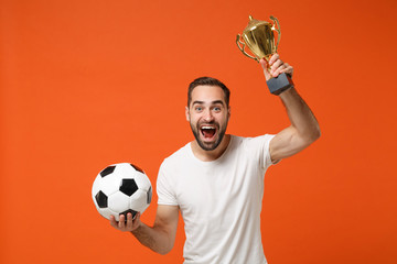 Excited young man in casual white t-shirt posing isolated on orange wall background studio...