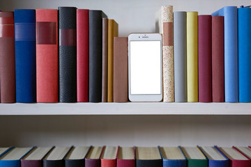 Mobile phone in bookshelf with sorted books