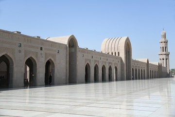 Fototapeta na wymiar Im Äußeren Sahn ist das Gebäude mit den Waschräumen für Männer und Frauen im Bogengang dem Riwaq in der Großen Sultan-Qabus-Moschee in Makat, Oman zu sehen.