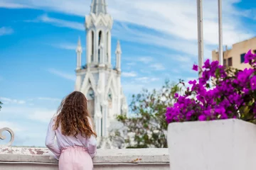 Fototapeten Beautiful young girl on the Ortiz Bridge looking at the famous gothic church of La Ermita built on 1602 in the city of Cali in Colombia © anamejia18