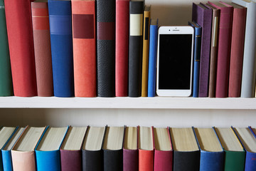 Accurate bookcase with mobile phone standing upright