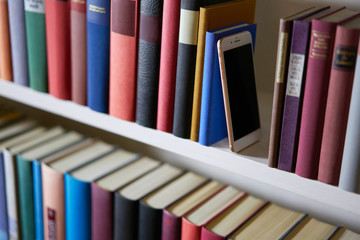 Mobile phone between various books from above