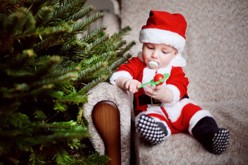 Christmas time and kid at home. Little funny boy dressed as Santa Claus. Winter magic holidays