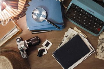 Investigator desk with confidential documents, vintage typewriter, film, magnifying glass and hat....
