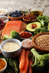 Healthy food clean eating selection: fish, fruit, vegetable, cereal, leaf vegetable on rustic background