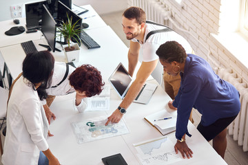creative international team with computers, laptop stand and discuss financial issues of business...