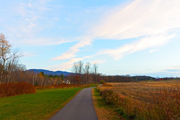 Trail in autumn in Stowe, Vermont, USA. Corn field in late autumn after crop picked up.