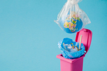 Earth globe lies in the trash. The globe lies in a heap of plastic. Plastic pollution of nature