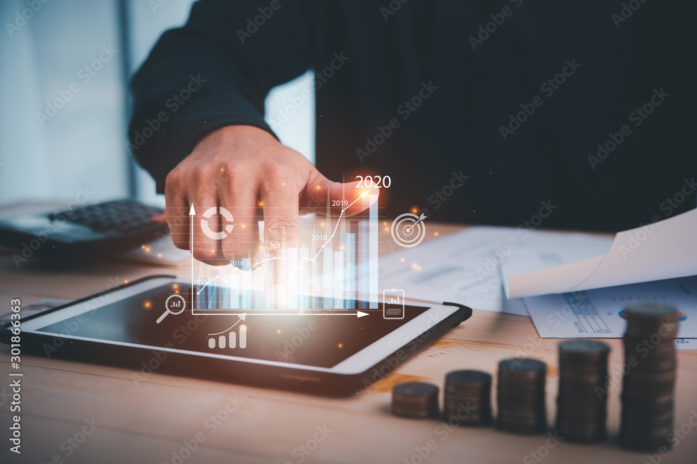 Poster businessman touch on digital tablet.business analytics and financial technology concept, virtual screen chart from the screen of digital tablet computer. indicators of positive growth in 2020.
