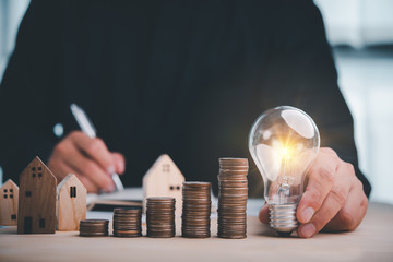 businessman holding lightbulb and use calculator . concept saving money and finance accounting for the future.idea innovation.