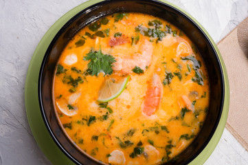  famous delicious Thai Tom yum spicy soup with shrimps and coconut milk on white table. close up