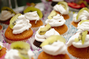 Obraz na płótnie Canvas colorful cupcakes with cream and kiwi
