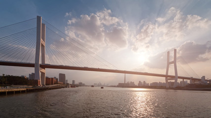 Brücke Shanghais Nanpu herein mit Sonnenunterganghintergrund, Hintergrundbeleuchtungslandschaft von Shanghai-Stadt, die vier chinesischen Schriftzeichen auf Brücke bedeuten Nanpu-Brücke.