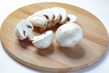  porcini mushrooms, champignons, on a white plate, on a wooden board, on a black plate