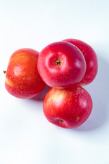 Red apples on a white plate, on a wooden, in a plate