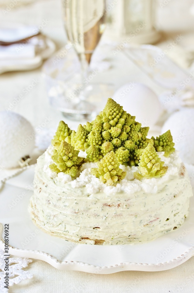 Wall mural crep cake for Christmas and New Year.  Christmas tree decorations cabbage romanesco. Snack cake with salmon, avocado and soft cheese. Grains of cottage cheese play the role of snowdrifts.