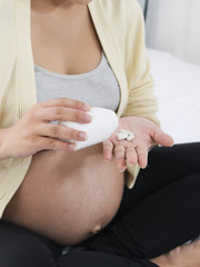 Asian pregnant woman with drugs in her hand, medical and health concept.