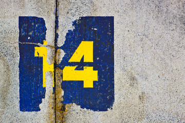 Number 14, fourteen, yellow and blue on gray background.