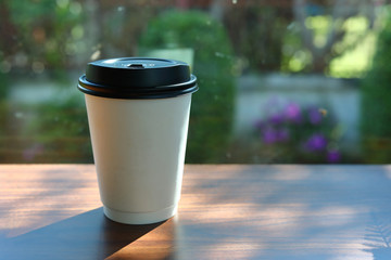 take away cup for hot coffee drink put on wooden table in cafe