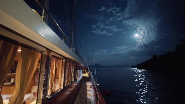 Revealing shot of a night luxury cruise with a moon on the sky at night luxurious in Turkey on mediterranean sea