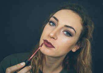 Obraz premium Portrait, beautiful girl, make-up, with smile posing on black background, makeup, powder, eye shadow, mascara, lipstick, eyeshadow