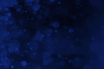 Blue light bokeh on a black background for the Christmas background, abstract.