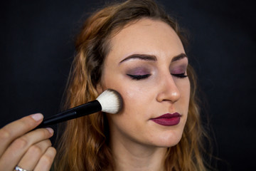 Obraz premium Portrait, beautiful girl, make-up, with smile posing on black background, makeup, powder, eye shadow, mascara, lipstick, eyeshadow