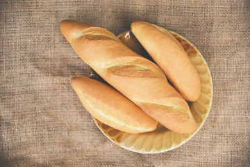 Homemade breakfast food concept / Bread and buns assortment fresh bakery on plate with sack background
