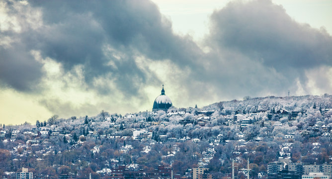Montreal skyline with first snow falling on Saint Joseph Oratory. Winter view with Mt Royal mount. Quebec Canada city travel North America destination. november 2019.