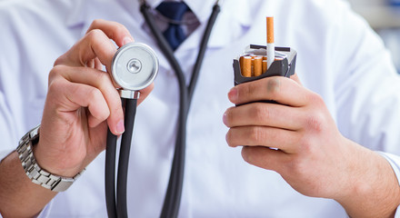 Male doctor in anti-smoking conceptwithcigarette pack