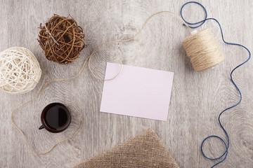 twine and two decorative balls, burlap and coffee mug on light gray wooden background. Space for text