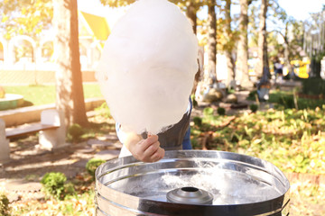 Saleswoman with tasty cotton candy in park