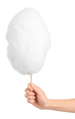 Female hand with tasty cotton candy on white background